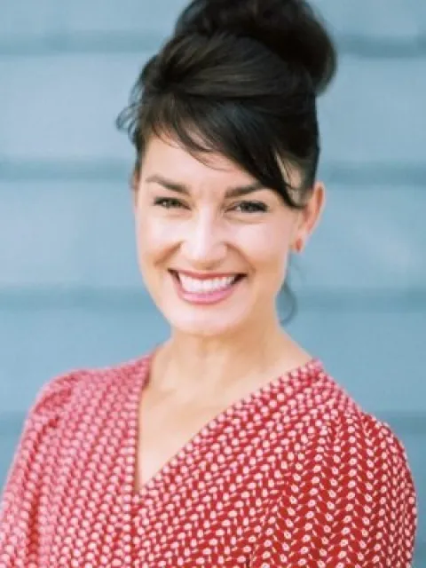 Headshot of woman with black hair and red dress