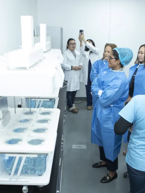 Group of women in lab blouses examining samples