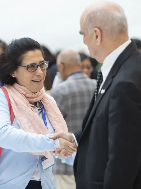 Women shaking hands with older man