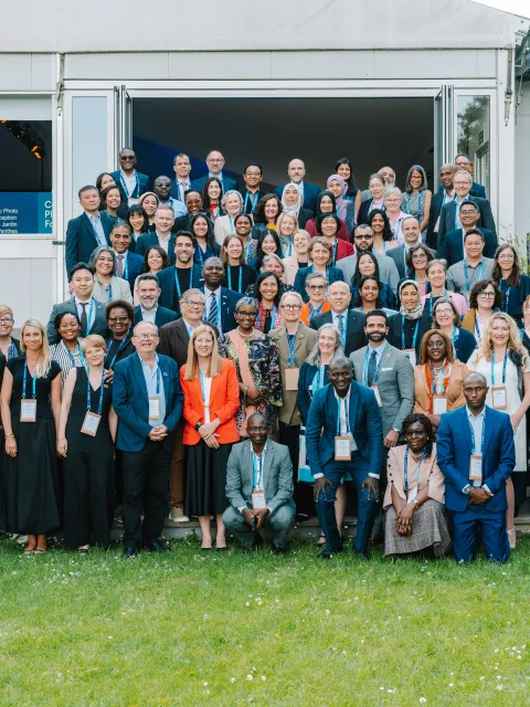 Diverse group of participants in a seminar posing outside a building