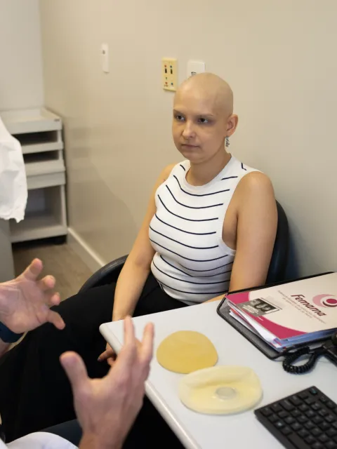 Woman with no hair speaking to a doctor