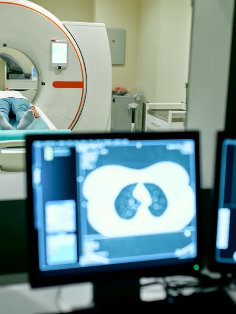 In the medical laboratory, the patient undergoes an MRI or CT scan under the supervision of a radiologist, in the control room, the doctor observes the procedure and monitors the scan results.