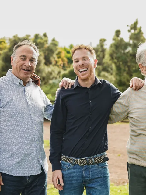 Multi generational men having fun together at city park - Multiracial male friends enjoy day outdoor