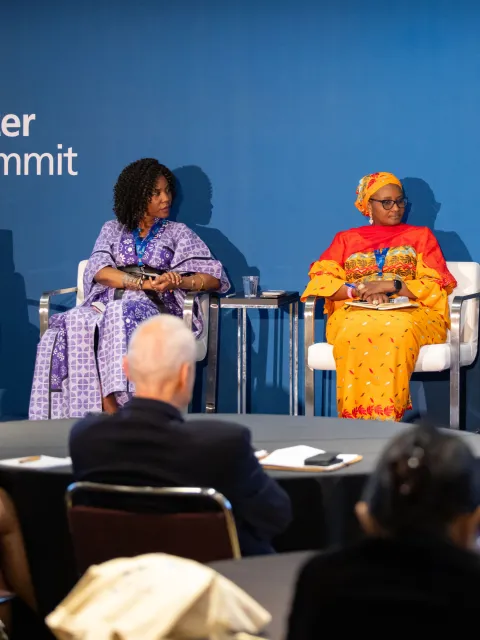 Diverse panel at World Cancer Leaders' Summit branded in background
