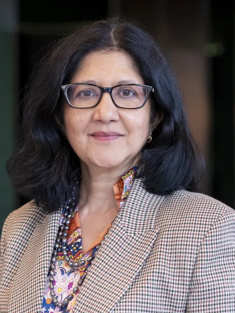 Headshot Asian woman wearing dark glasses and suit top