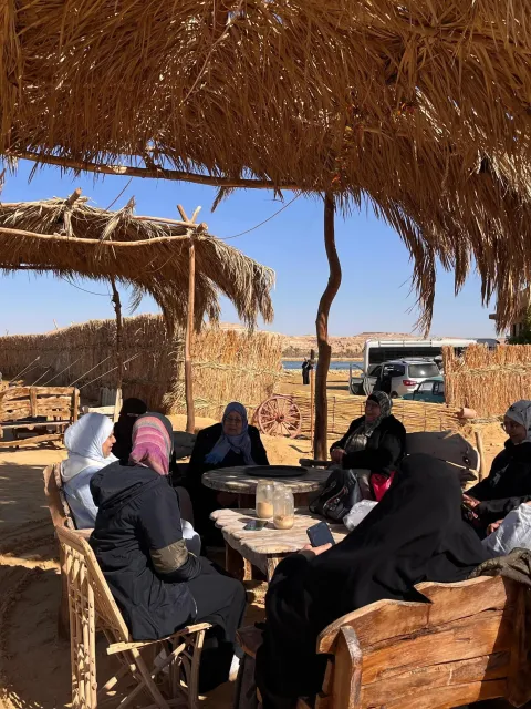 Group of Middle Eastern women sitting at a table in a desert village