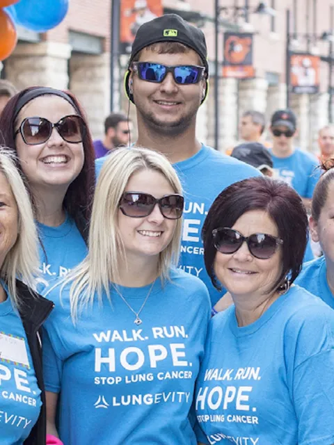 Diverse group of men and women in a branded LUNGevity shirts before a 5k walk event