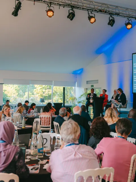 Diverse group of people sitting at round tables at an event