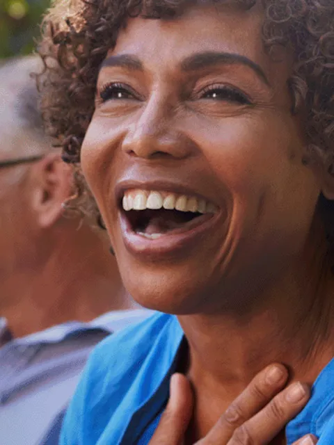 Black woman smiling and text overwrite "Early Detection = Better Outcomes"