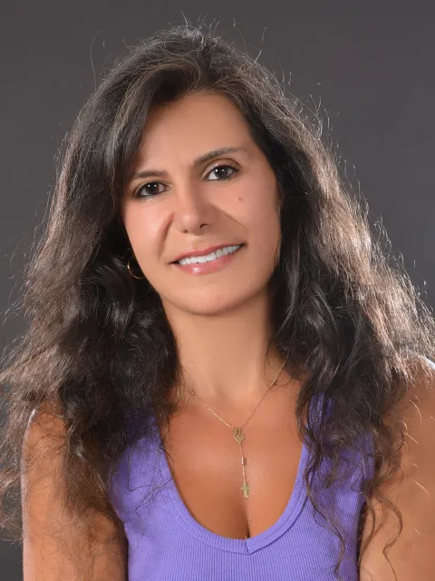 Headshot Middle Eastern woman, wearing a purple crop top