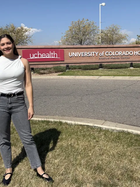 Young Latin American woman standing in front of the University of Colorado