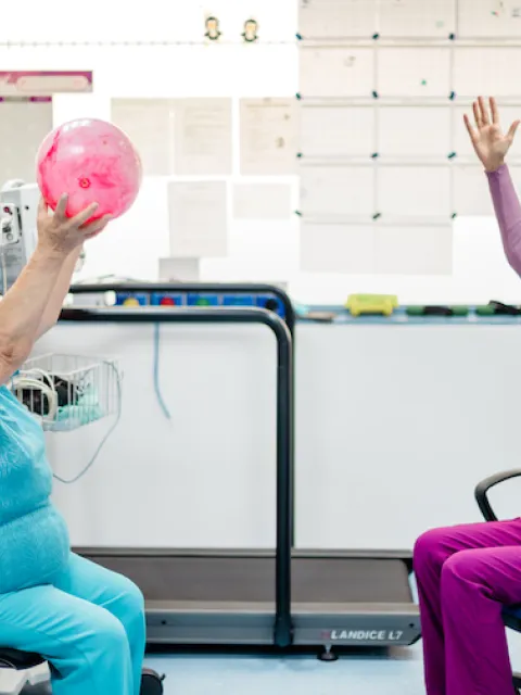 Older patient doing physical exercise with a healthworker