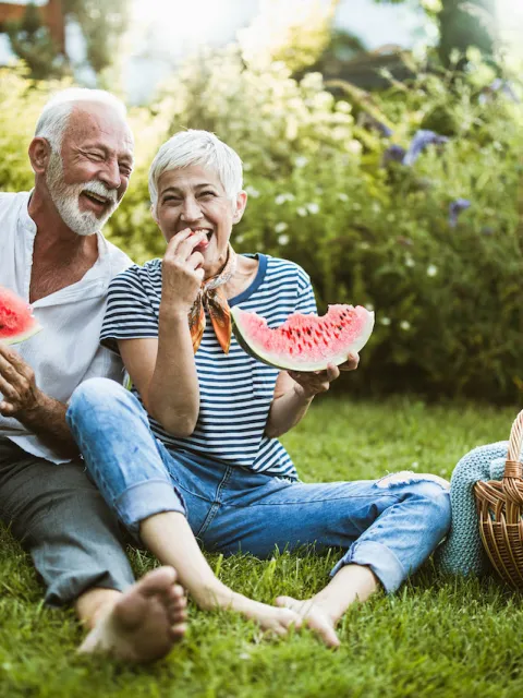 Elderly couple eating watermelon symbolising a healthier lifestyle through nutrition