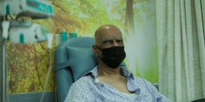 Man wearing a mask undergoing cancer treatment