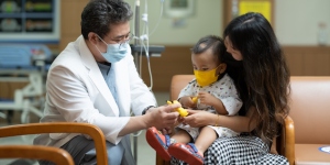 Doctor speaking to a woman and her child. (C) National Cancer Center - Korea (NCCK)