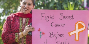 Woman at a breast cancer awareness campaign in Pakistan holding up a signpost that says: "Fight breast cancer before it starts". Photo by UICC is offering grants to members for projects aimed at improving access to early detection. Photo by Salman Asif/UN Women Asia and the Pacific,  breast cancer awareness campaign in Pakistan in 2013.