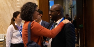 Two people attending a UICC event greeting one another.