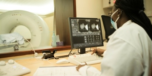 Health worker at Aga Khan University Hospital in Kenya studying MRI scans of a cancer patient