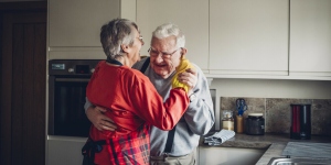 Elderly Caucasian couple dancing in a kitchen